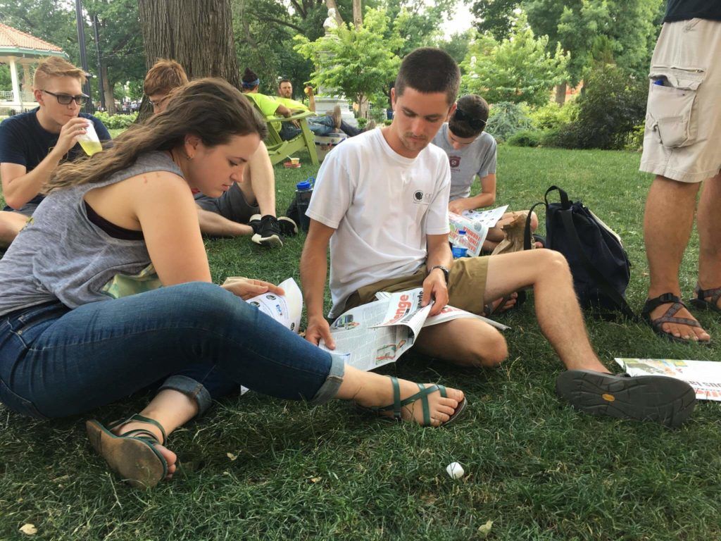 people on lawn reading paper